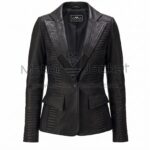 front view of Black Padded Leather Blazer featuring wide peak lapels, one button, flap pockets, and horizontal ribbed stitching on the sides and sleeves with Maker Of Jacket brand label.
