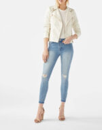 Model wearing white studded moto jacket paired with skinny blue jeans
