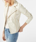 Close-up of metallic studs on women's white biker leather jacket