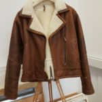 Men’s brown leather flying jacket with sheepskin collar and classic biker design.