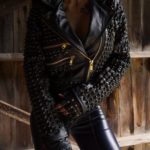 Close-up of gold zipper and stud accents on black biker genuine leather jacket