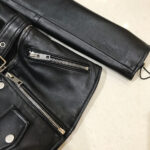 Edgy black leather jacket with silver hardware and structured pocket design for modern look.