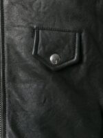 Black leather jacket with leopard print front panel, studded right shoulder, and red zipper pocket for a bold, edgy look.