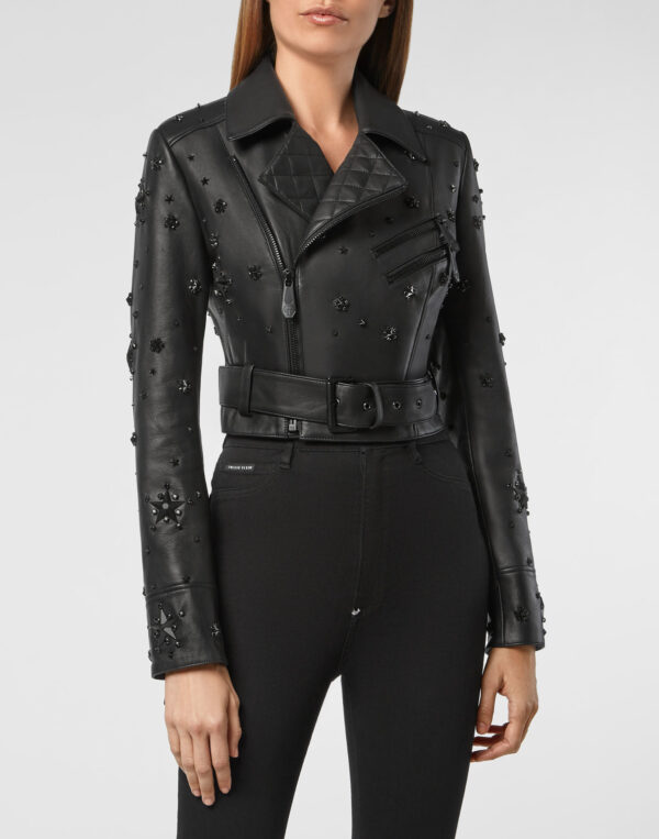 Black leather jacket with star and bead embellishments, quilted panels, zippers, and a belt for a sleek, edgy style.
