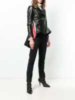 Women's black leather moto coat featuring fringe accents on sleeves and back for an edgy, vintage look.