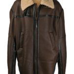 Relaxed fashion look with oversized brown shearling coat, black base outfit, and white sneakers for contrast.