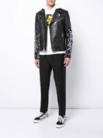 Black leather jacket with silver zippers and bold skull and crossbones sleeve accents, exuding punk rock attitude.