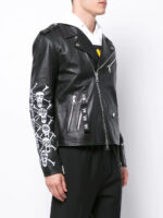 Rebellious black biker jacket featuring white skull graphics on sleeves, silver hardware, and classic leather construction.