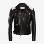 A black leather biker jacket with silver zippers and white shoulder panels on a plain white background, conveying a sleek, edgy style.