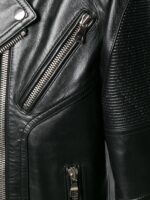 Studded black leather motorcycle jacket with belted waist and zipper details, crafted for a fierce, fashion-forward appearance.