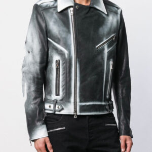 A person wears a black and silver gradient leather jacket with asymmetrical zippers and a structured collar, paired with black pants. The style is edgy and modern.