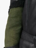 Bold black and green leather jacket with asymmetrical zipper, woolly collar, and belt details for a contemporary biker style.