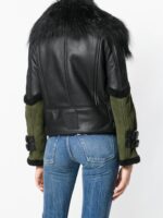 Fashion-forward leather jacket with black body, green sleeves, fur collar, and silver hardware for a striking, modern look.
