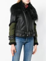 Edgy black leather jacket featuring a plush fur collar, asymmetrical front zip, and contrasting green sleeves with belted accents.