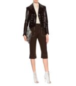 Fashionable outfit featuring a dark leather jacket, beige blouse, brown capri pants with white stitching, white lace-up heels, and a snakeskin clutch.