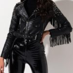 Edgy black leather outfit featuring a studded jacket with waist belt, layered over a turtleneck and styled with glossy vinyl pants.