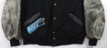 The Vintage NFL Carolina Panthers Varsity Jacket features worn gray leather sleeves, leather-trimmed pockets, brass buttons, and a left pocket with a blue and black Panthers logo plus team text for true fan pride.