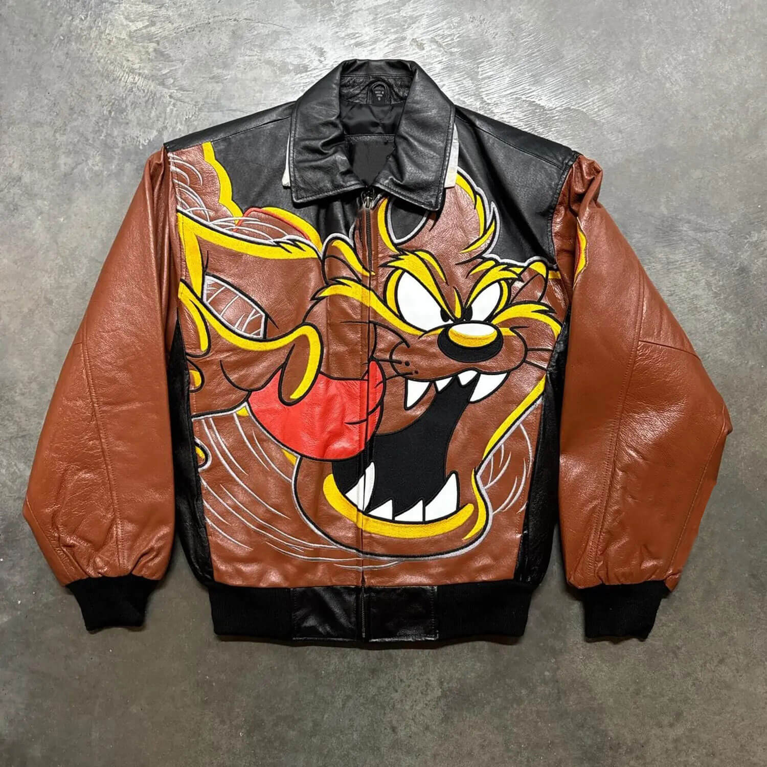 Rare Tasmanian Devil Leather Jacket (2) A Tasmanian Devil leather jacket with brown sleeves and a large graphic of the Tasmanian Devil cartoon character on the front.