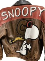 A Closeup of Snoopy Cartoon Leather Jacket featuring a large image of Snoopy wearing goggles and scarf, with “SNOOPY” written in large white letters on the back.