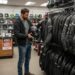 Motorcyclist examining jackets in gear shop
