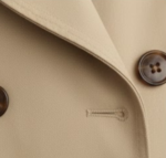 Beige trench coat button and stitching close-up