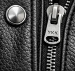 Close-up YKK zipper on black leather texture