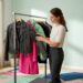 Woman inspecting jackets at hallway rack