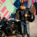 Motorcyclist checks padding in jacket outdoors