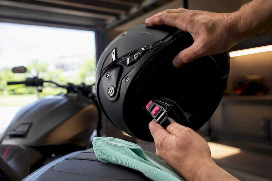 Hands checking motorcycle helmet chin strap