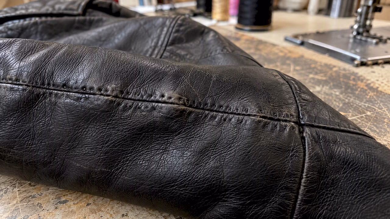 Permanent stitch holes visible in leather