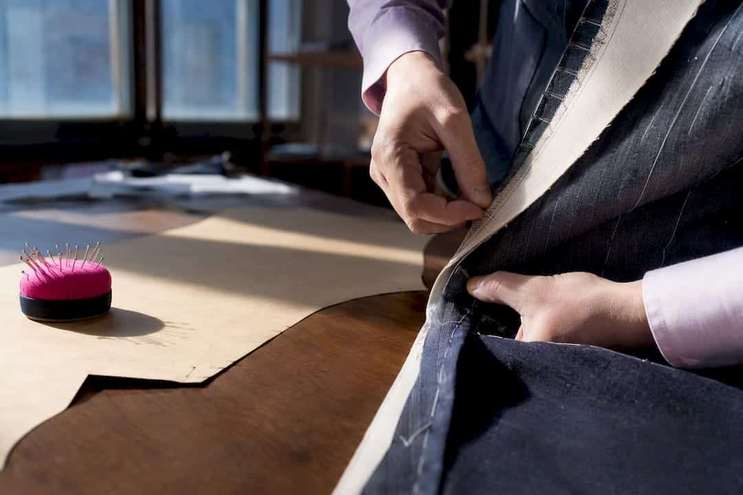 Cutter correcting a basted garment fitting