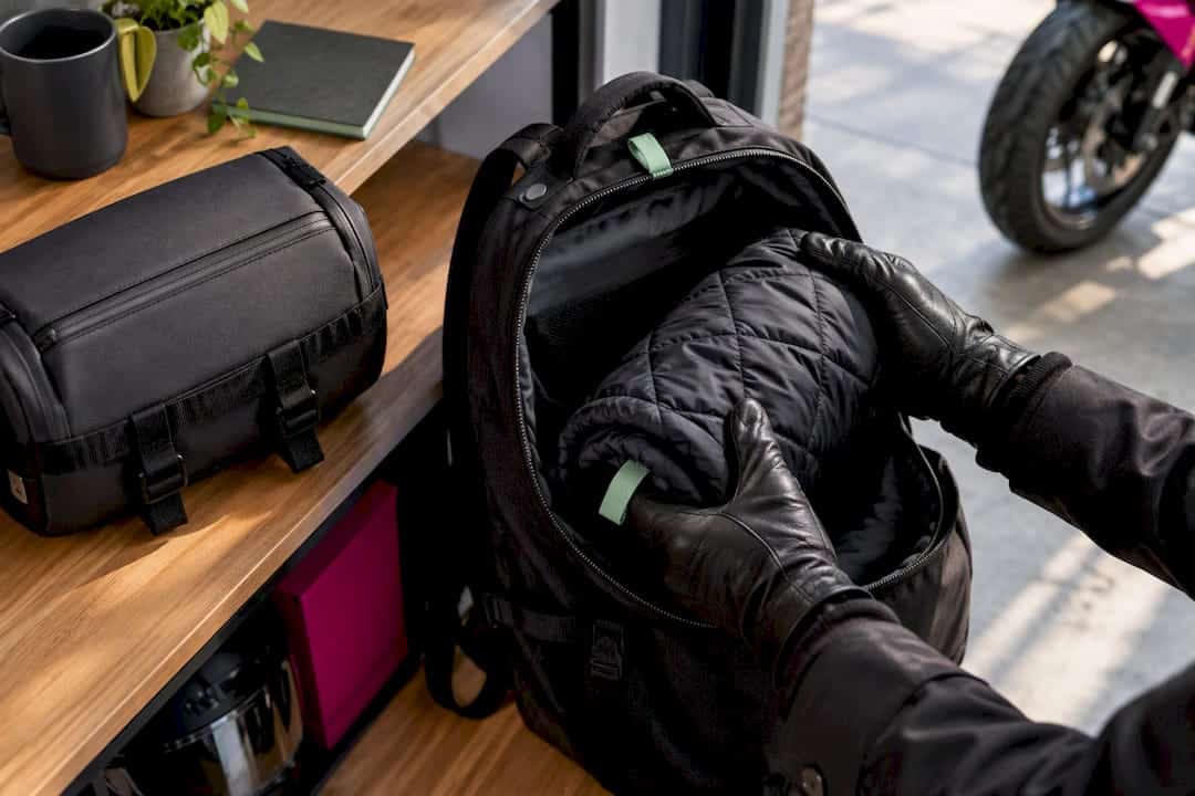 Commuter stowing rolled liner in backpack