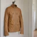 Tan leather jacket hanging in a shaded alcove